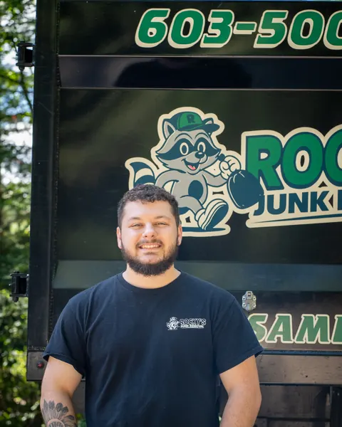 Devin from Rocky's Junk Removal in front of the Rocky's dump truck