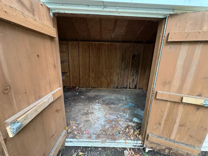 The same shed empty and swept after the cleanout