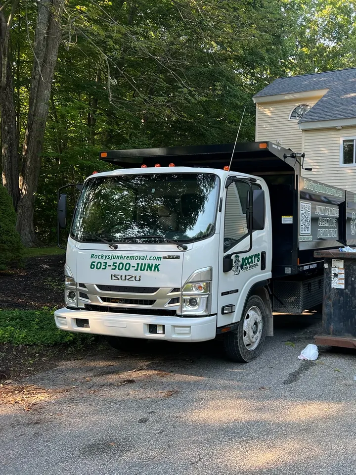 Rocky's Junk Removal truck parked in the driveway of a house during a property cleanout