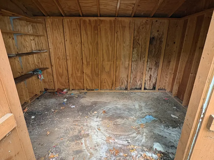 The same Hudson, NH shed completely empty down to the wood floor after Rocky's Junk Removal cleared it
