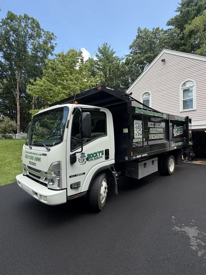 Rocky's Junk Removal truck backed into a shaded Londonderry, NH driveway