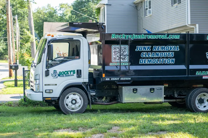 Rocky's Junk Removal dump truck parked on the lawn in front of a Londonderry, NH home