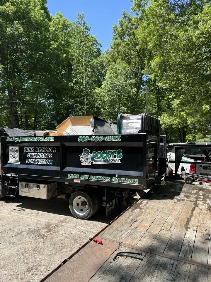 Rocky's Junk Removal truck bed loaded with lumber and demolition debris from a Pelham, NH job